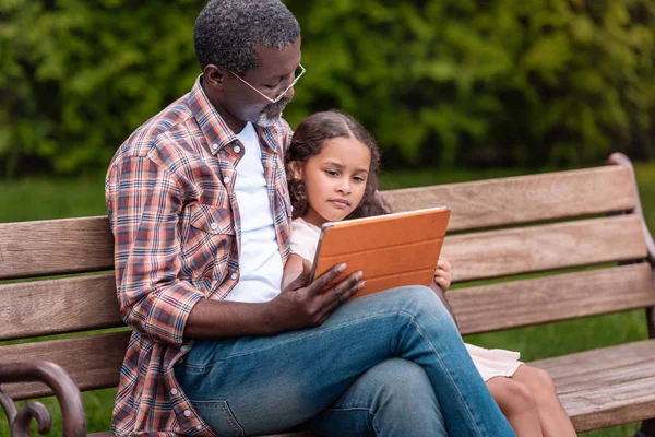 Fille et grand-père en utilisant une tablette numérique — Photo de stock