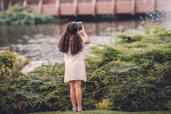 Chica tomando fotos en el teléfono inteligente - foto de stock