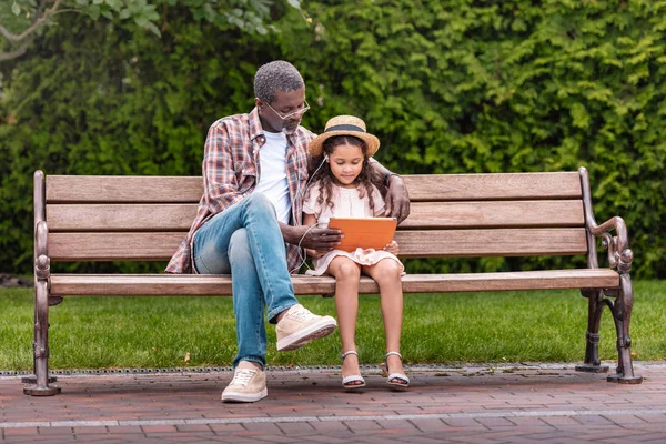 Granddaughter and grandfather listening music — Stock Photo