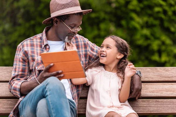 Granddaughter and grandfather listening music — Stock Photo