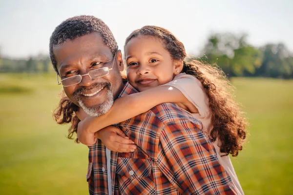 Petite-fille embrassant son grand-père — Photo de stock