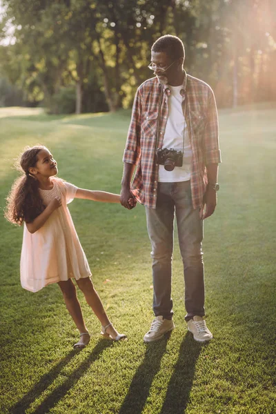 Hombre afroamericano cogido de la mano con su nieta - foto de stock