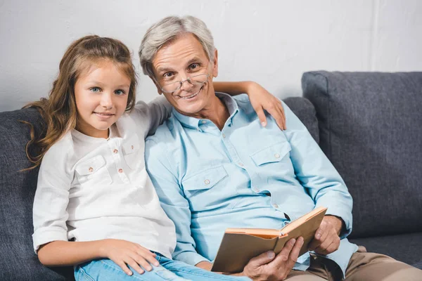 Livre de lecture grand-père et petite-fille — Photo de stock