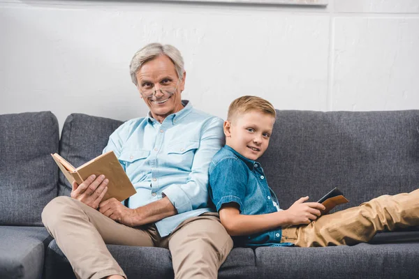 Família com livro e tablet digital — Fotografia de Stock