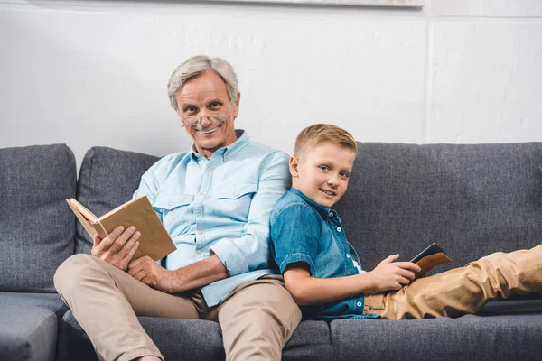 Famille avec livre et tablette numérique — Photo de stock