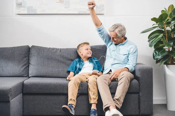 Abuelo y nieto escuchando música - foto de stock