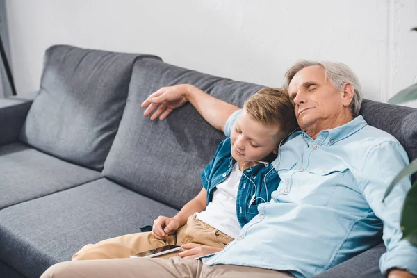 Grand-père et petit-fils dormant sur le canapé — Photo de stock