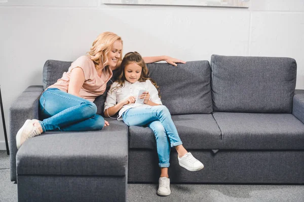 Grandmother and granddaughter listening music — Stock Photo