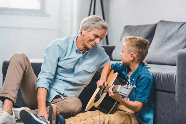 Grand-père et petit-fils jouant à la guitare — Photo de stock