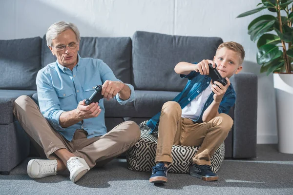 Abuelo y nieto jugando videojuego - foto de stock