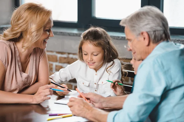 Grandparents and granddaughter drawing together — Stock Photo