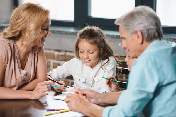 Grands-parents et petite-fille dessinant ensemble — Photo de stock