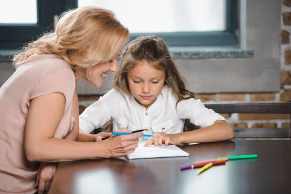 Grandmother and granddaughter drawing together — Stock Photo