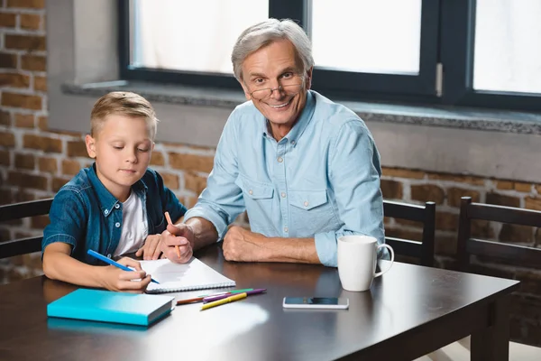 Grand-père et petit-fils dessinant ensemble — Photo de stock