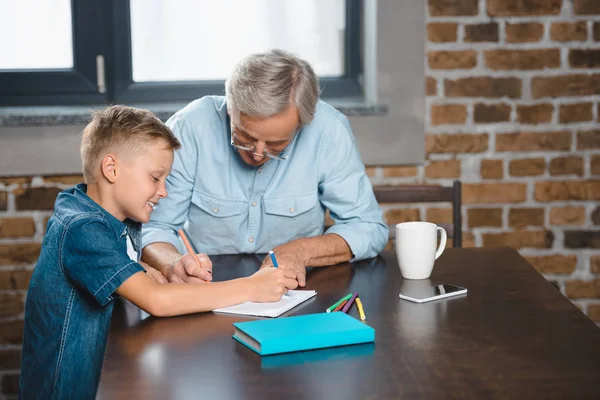 Abuelo y nieto dibujando juntos - foto de stock