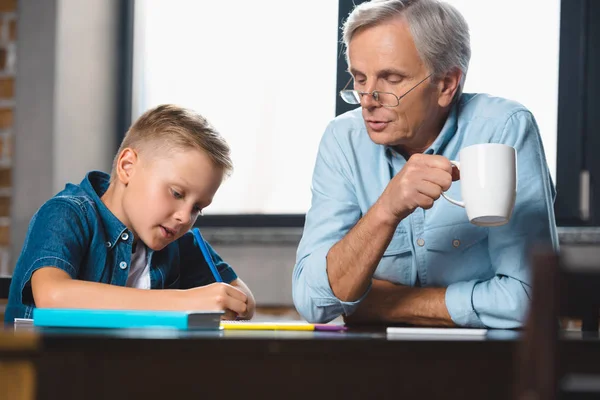 Grand-père et petit-fils dessinant ensemble — Photo de stock