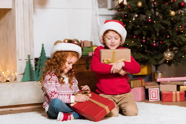 Crianças em santa claus chapéus com presentes — Fotografia de Stock