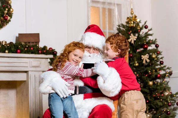 Santa claus and children with digital devices — Stock Photo