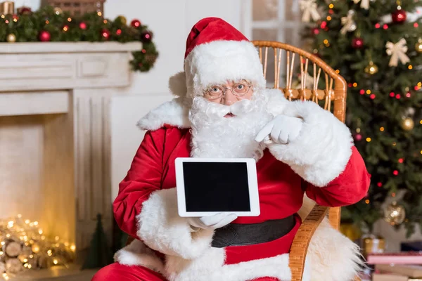 Santa claus pointing at tablet — Stock Photo