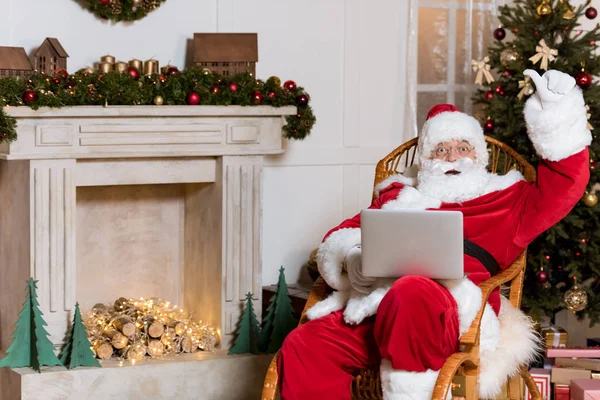 Santa claus com laptop em casa — Fotografia de Stock