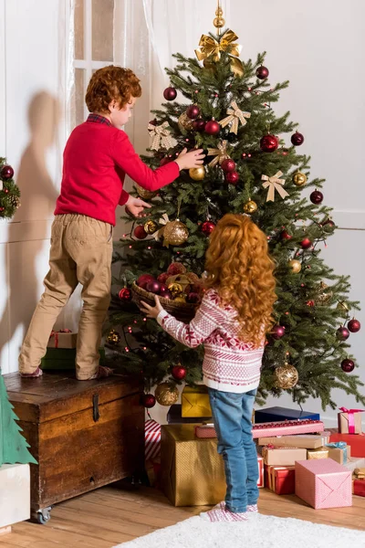 Irmãos decorando árvore de Natal — Fotografia de Stock