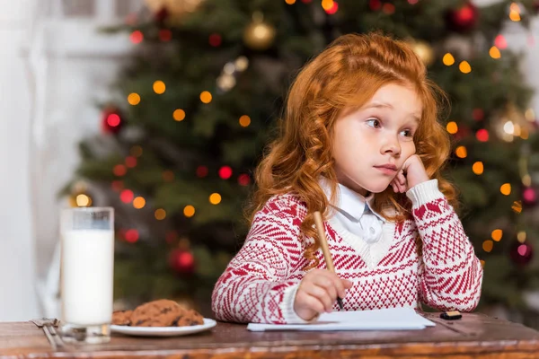 Nachdenkliches Kind sitzt am Tisch — Stockfoto