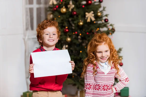 Niños felices con papel en blanco - foto de stock