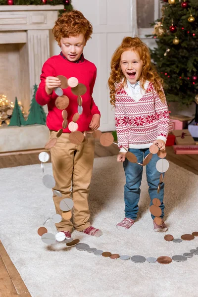 Niños felices con guirnalda festiva - foto de stock