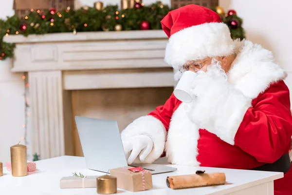 Papai Noel digitando no laptop — Fotografia de Stock