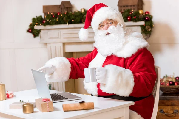 Weihnachtsmann mit Laptop zu Hause — Stockfoto