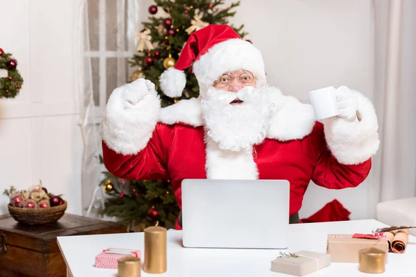 Weihnachtsmann mit Laptop zu Hause — Stockfoto
