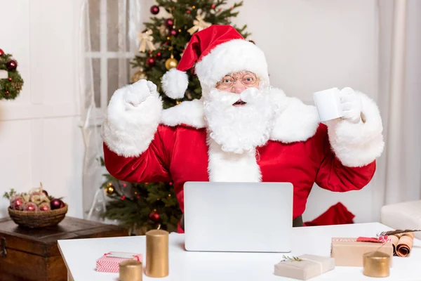 Santa claus com laptop em casa — Fotografia de Stock