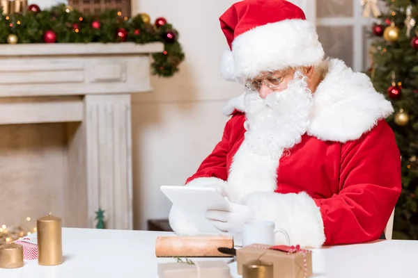 Santa claus using tablet — Stock Photo