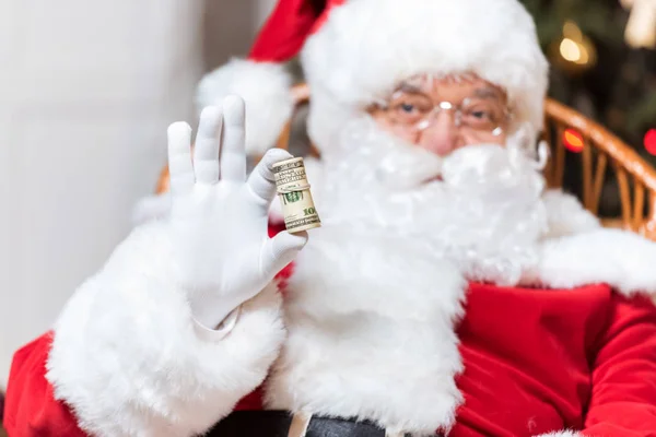 Santa claus with roll of money — Stock Photo