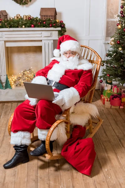 Santa claus avec ordinateur portable à la maison — Photo de stock