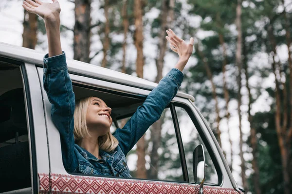 Chica alegre en minivan retro - foto de stock