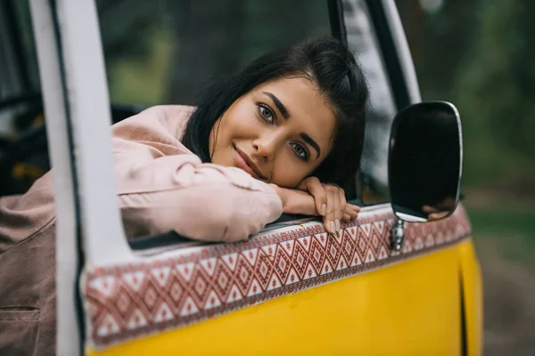 Chica sonriente en minivan retro - foto de stock