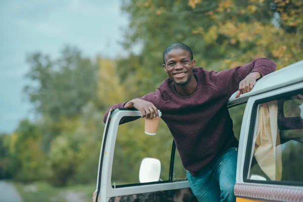 Afro homem com café em minivan — Fotografia de Stock