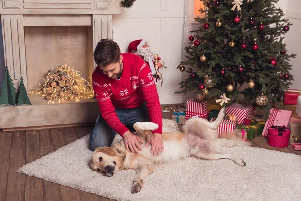 Homme jouer avec chien à christmastime — Photo de stock