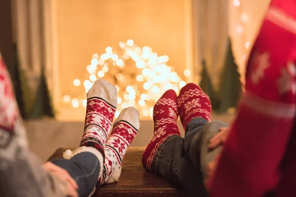 Couple en chaussettes tricotées près de la cheminée — Photo de stock