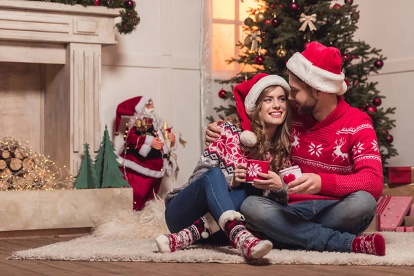 Pareja con tazas en Navidad - foto de stock