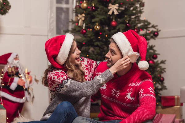 Casal feliz em chapéus de santa — Fotografia de Stock