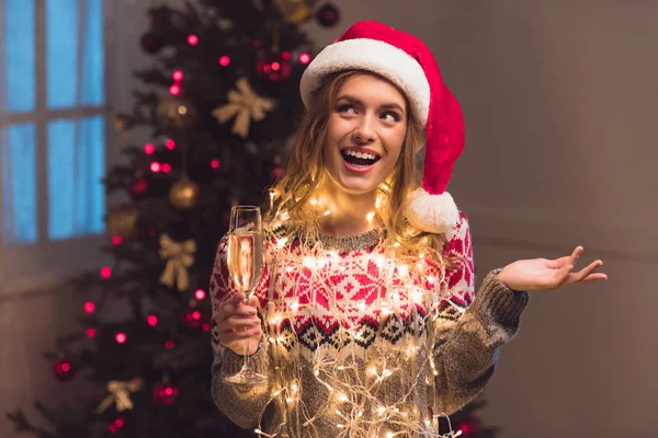 Ragazza in cappello di Babbo Natale bere champagne — Foto stock