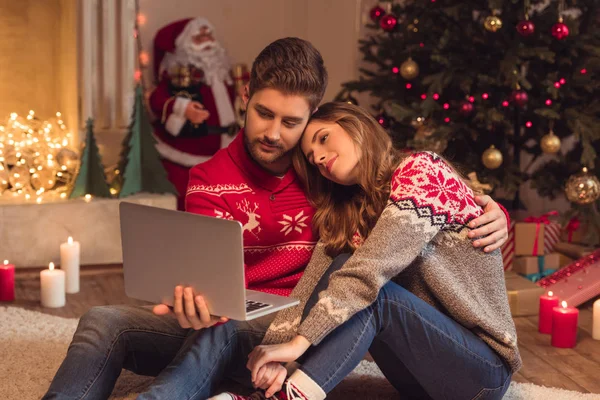 Pareja con el ordenador portátil en Navidad - foto de stock