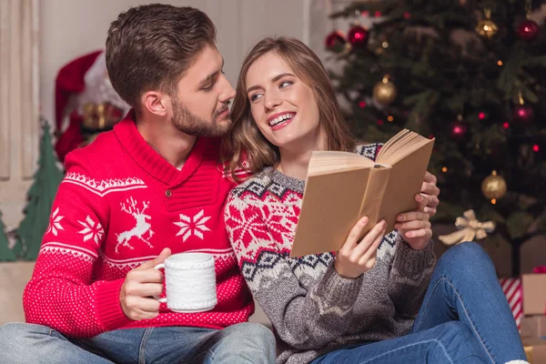 Paar liest Buch zur Weihnachtszeit — Stockfoto