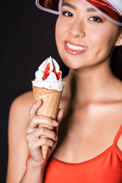 Mujer en traje de baño y visera sosteniendo helado — Stock Photo