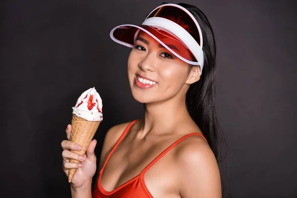 Woman in swimsuit and visor holding ice-cream — Stock Photo