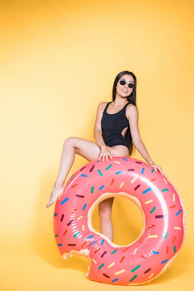 Женщина в купальнике с платформой для бассейна с пончиками — стоковое фото