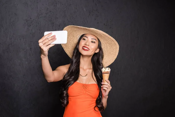 Woman holding ice-cream and taking selfie — Stock Photo