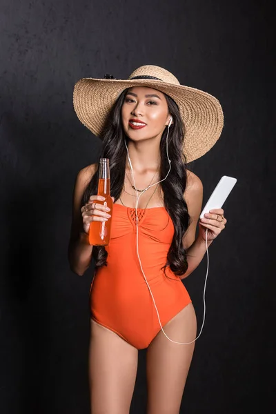 Mulher de maiô segurando smartphone e refrigerante — Fotografia de Stock